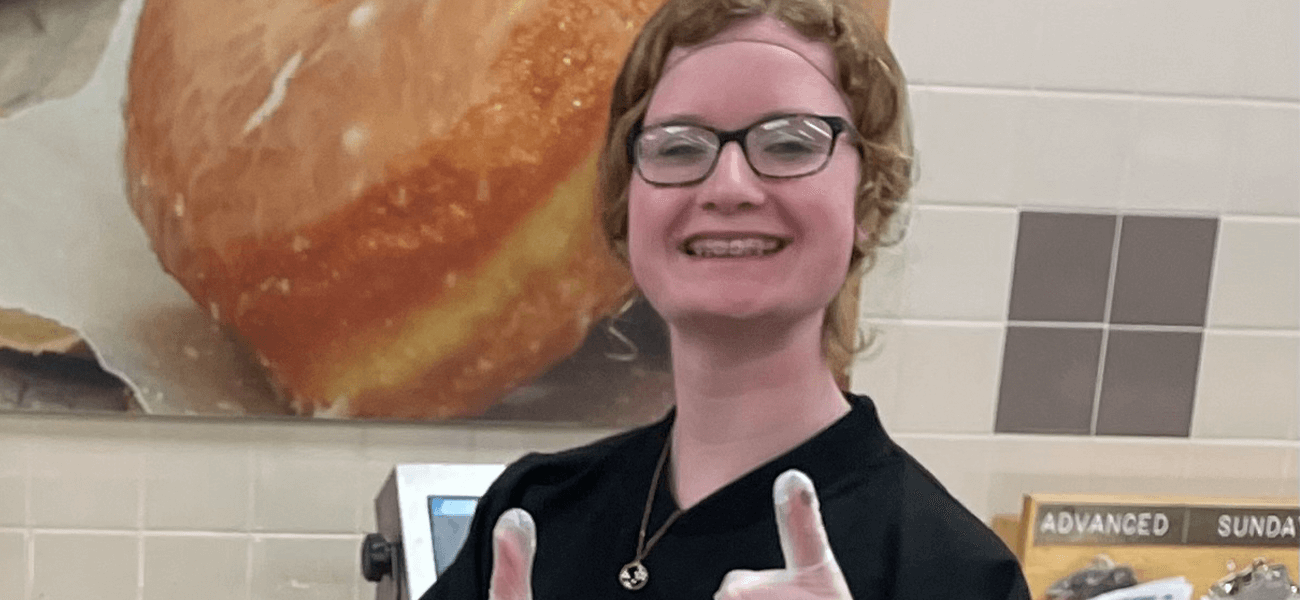 A female wearing a hair net and glasses with two thumbs up