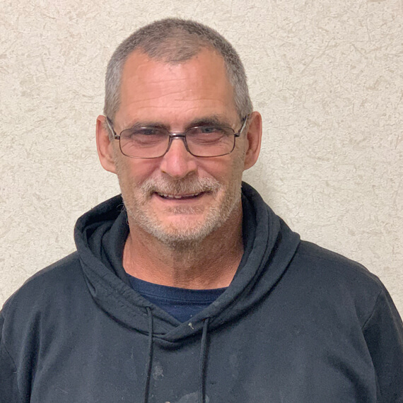 man-with-glasses-standing-against-wall