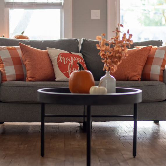 A couch with fall throw pillows
