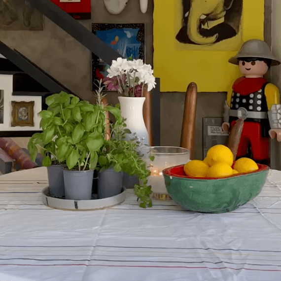 A watermelon bowl with lemons in it on a table.