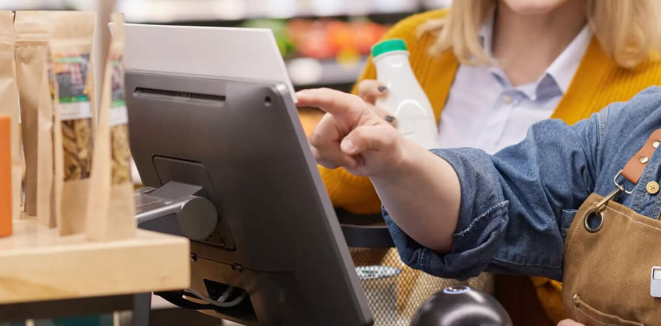 A worker helping a customer out at self-check