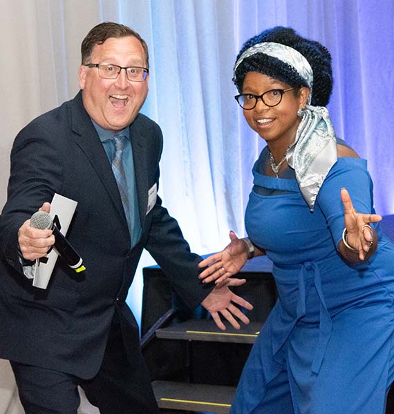 Hosts for the Power of Work Event, a man and woman, stand side by side