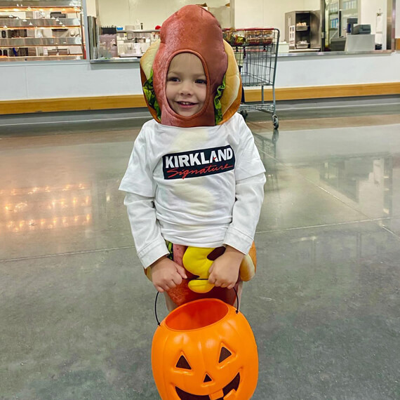 A male boy dressed in a hotdog Halloween costume